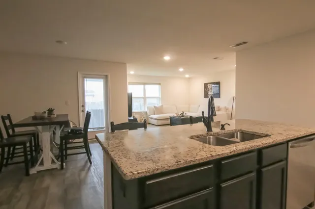 a kitchen with stainless steel appliances granite countertop a sink stove and refrigerator