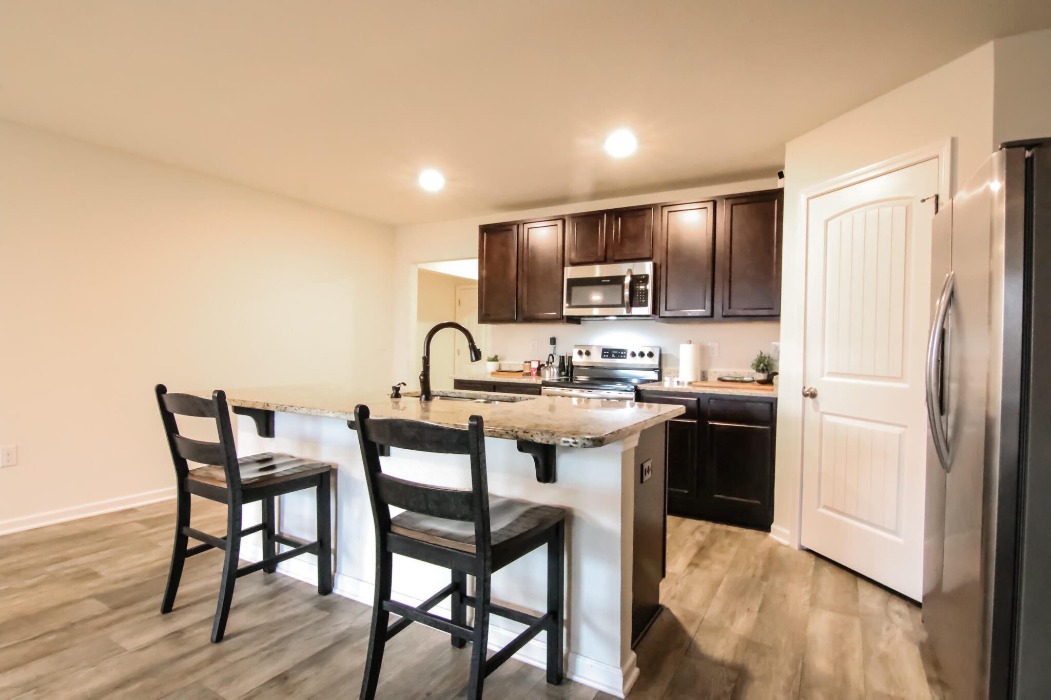 808 Moorhen Way Crestview, FL 32539 - Photo 7 of 47 a kitchen with a table chairs refrigerator and microwave