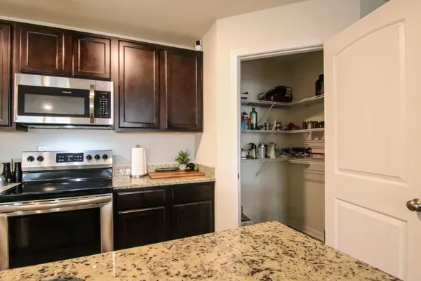 a kitchen with a dining table chairs and refrigerator