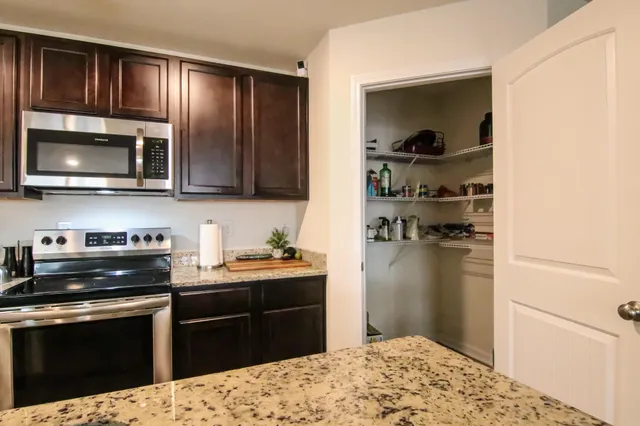 a kitchen with a dining table chairs and refrigerator