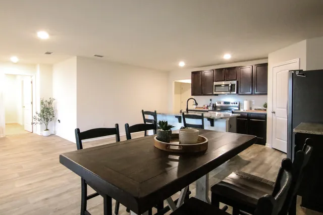 a view of kitchen with refrigerator stove dining table and chairs