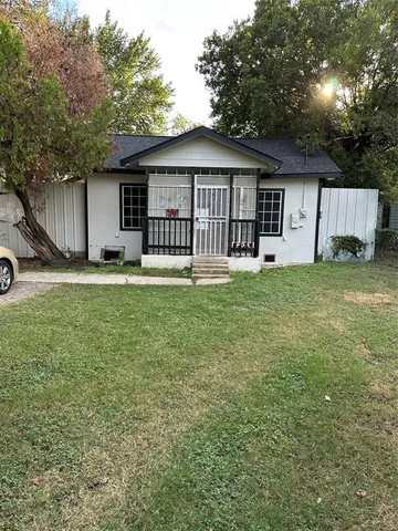 a front view of a house with a yard and trees