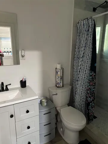 a bathroom with a sink toilet and mirror
