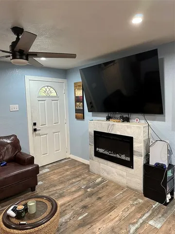a living room with furniture a flat screen tv and a fireplace