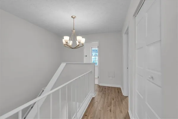 an empty room with wooden floor closet and windows