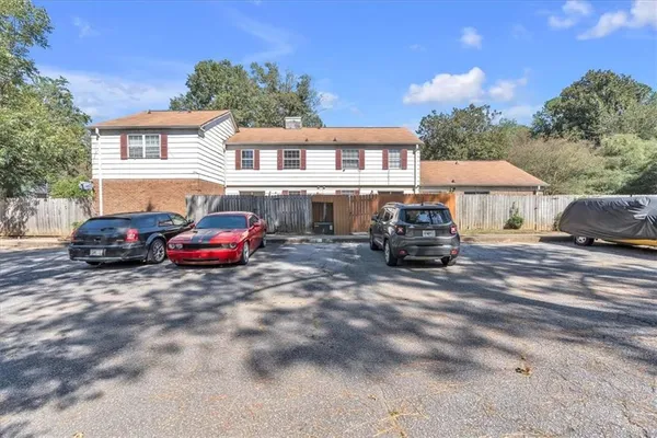 a front view of a house with cars parked on road