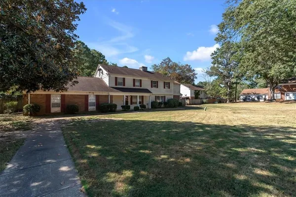 a front view of a house with a garden and yard
