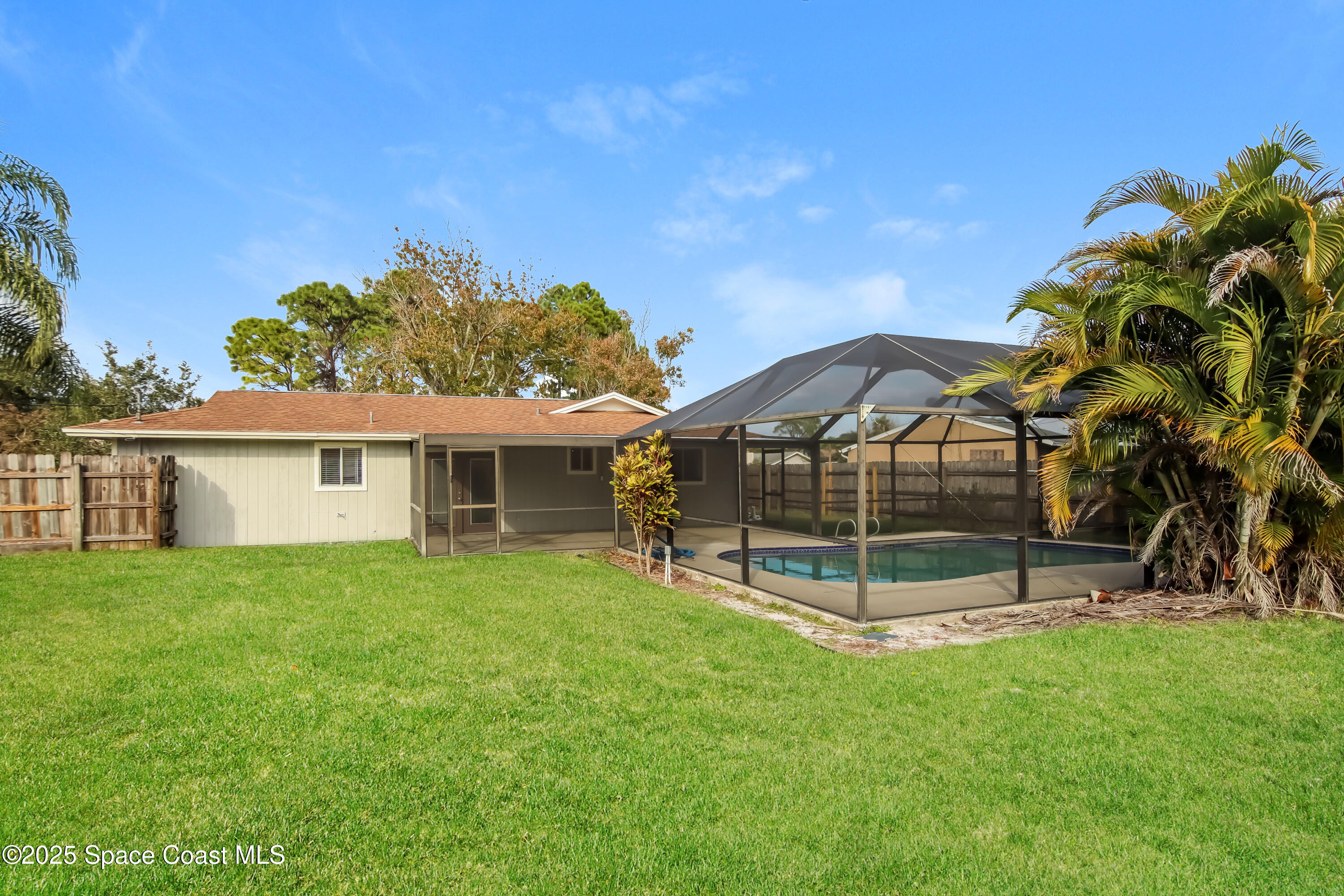 1130 Emerald Road Southeast Palm Bay, FL 32909 - Photo 14 of 16 a view of a house with a backyard and a tree