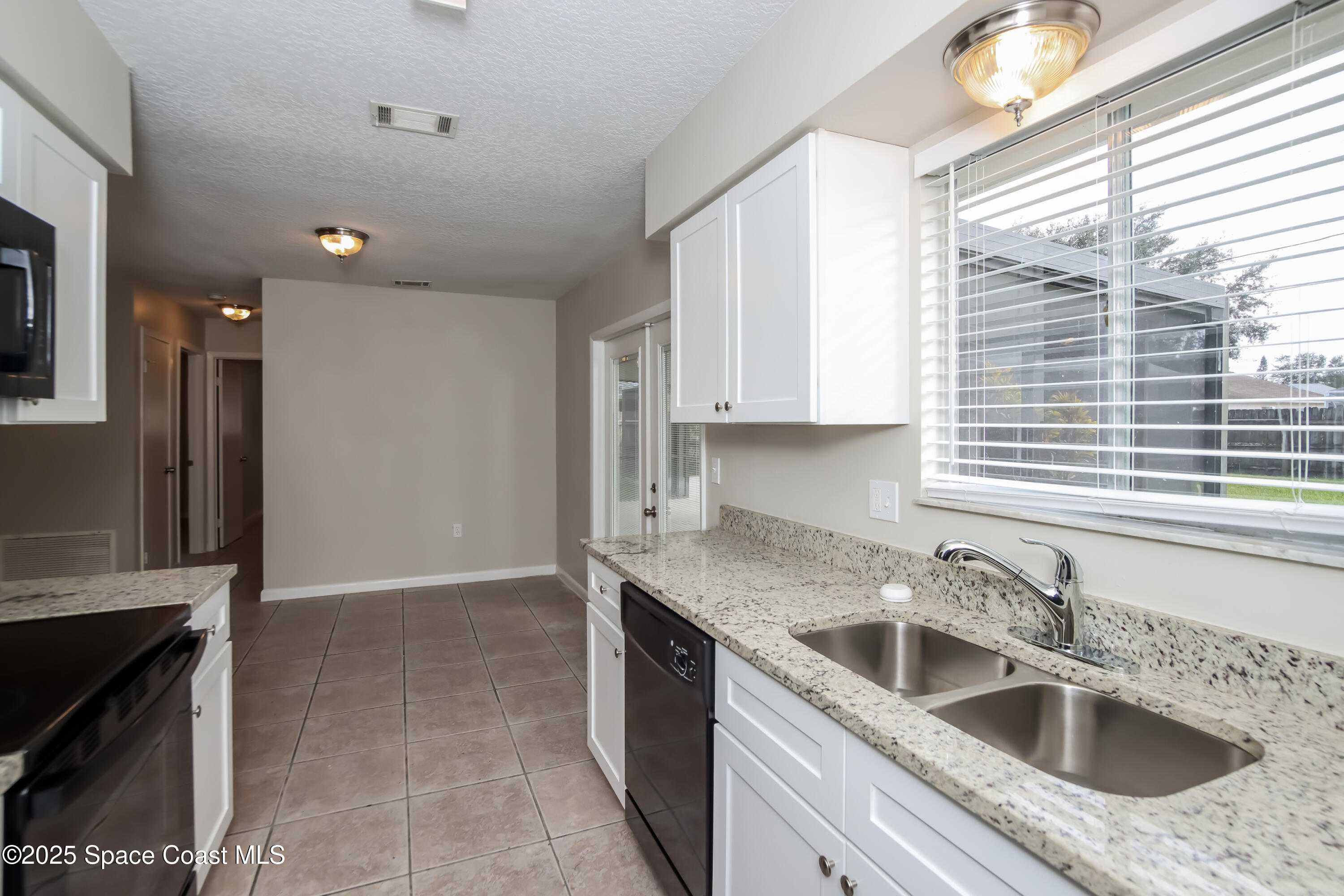 1130 Emerald Road Southeast Palm Bay, FL 32909 - Photo 6 of 16 a kitchen that has a sink cabinets counter space and appliances