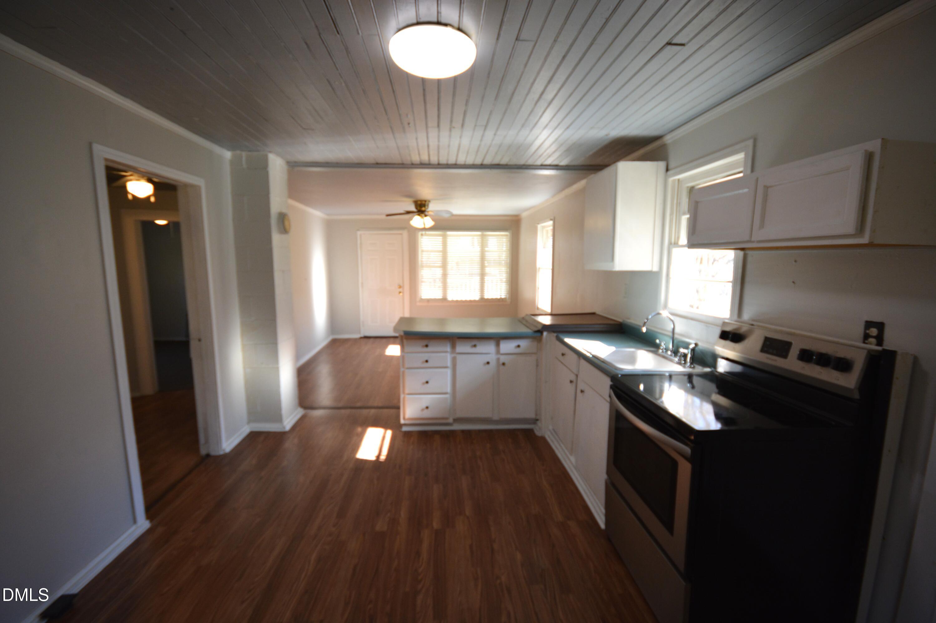 1324 Raleigh Road Oxford, NC 27565 - Photo 7 of 18 a kitchen with granite countertop a stove refrigerator and wooden floor