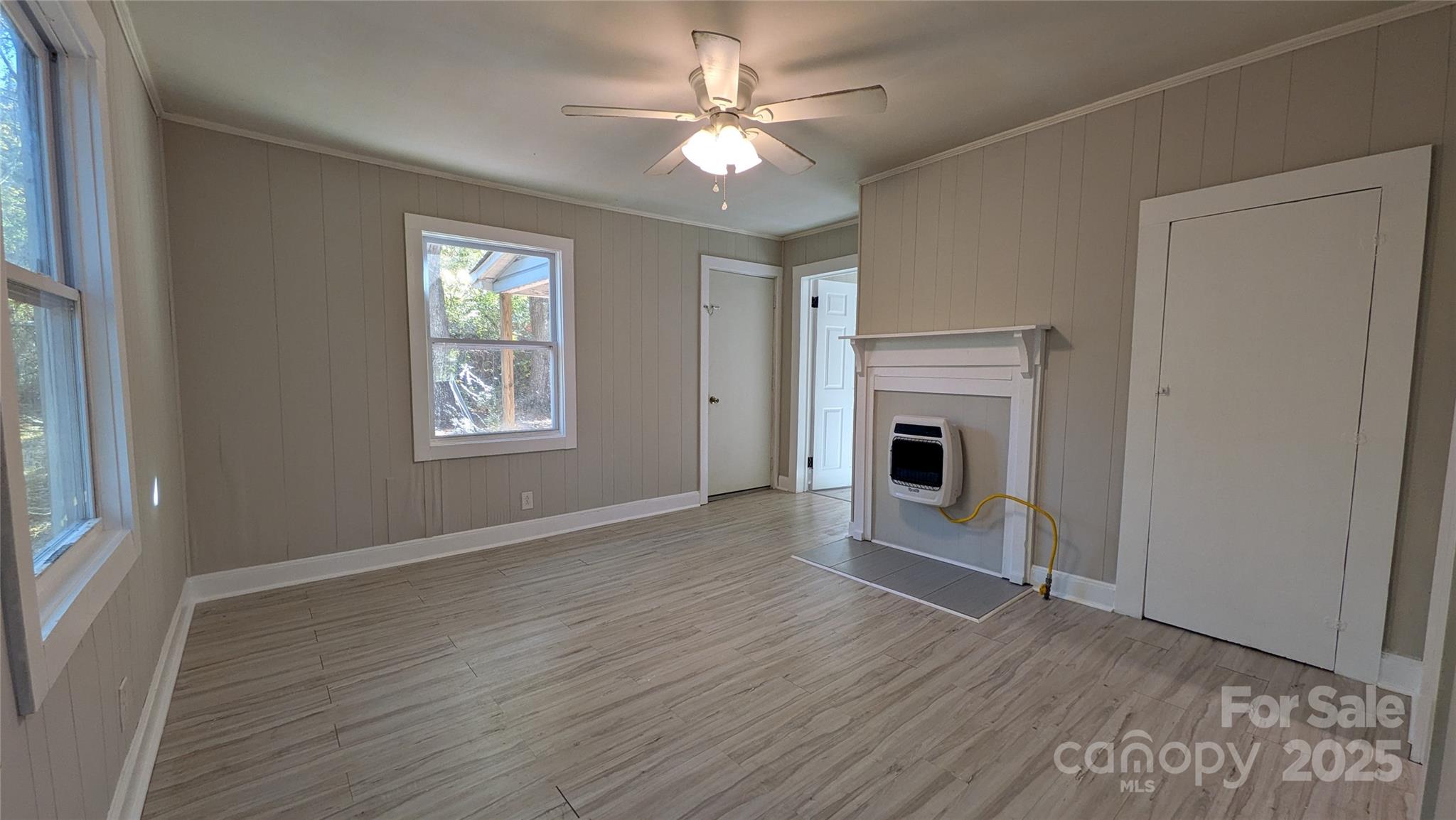 110 Dye Street Chester, SC 29706 - Photo 13 of 22 an empty room with windows a fireplace and a chandelier fan