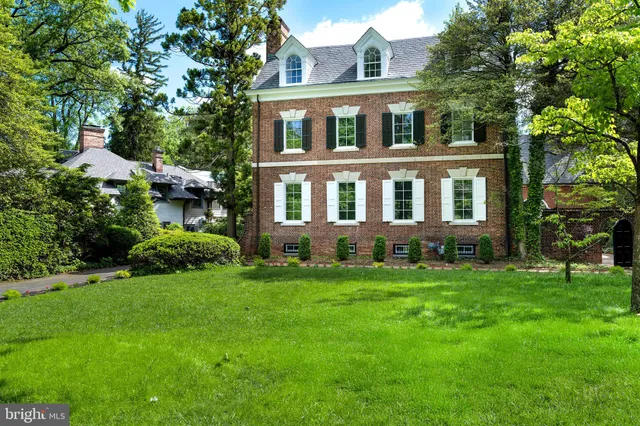 a front view of a house with a yard and trees