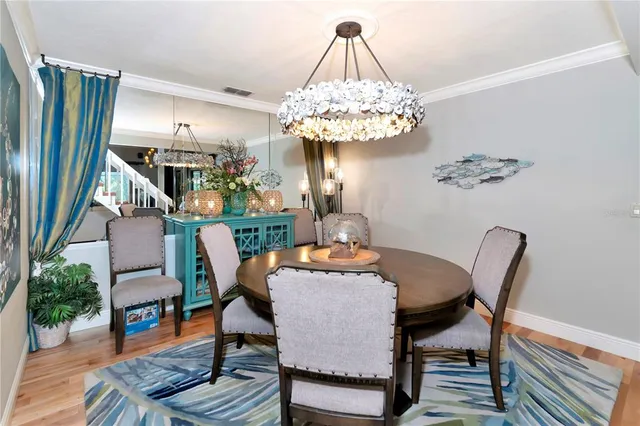 a dining room with furniture a chandelier and wooden floor