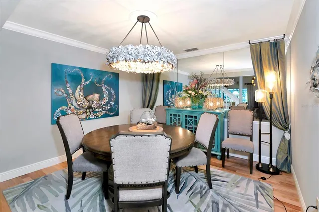 a view of a dining room with furniture a chandelier and wooden floor