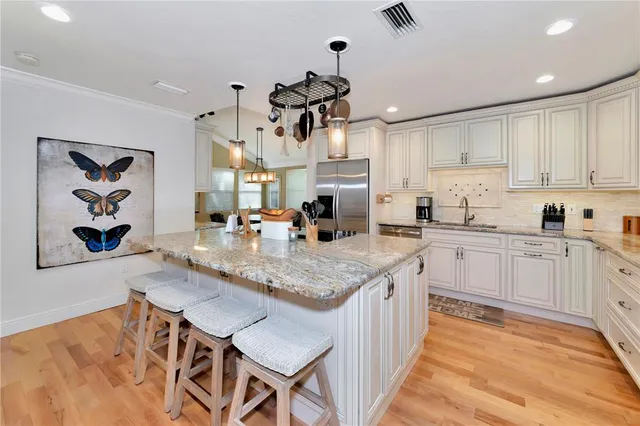 a kitchen with a dining table chairs sink and cabinets