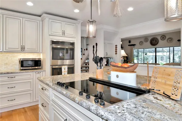 a kitchen with stainless steel appliances granite countertop a sink a stove and a refrigerator