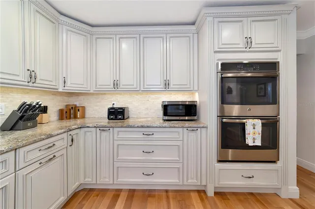 a kitchen with white cabinets and sink