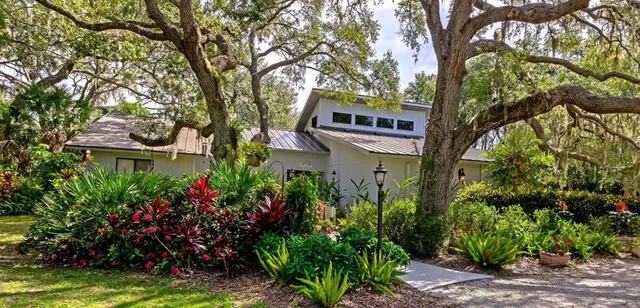 a front view of a house with a yard and fountain in middle of the house
