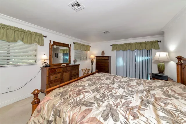 a large bedroom with a bed and wooden floor