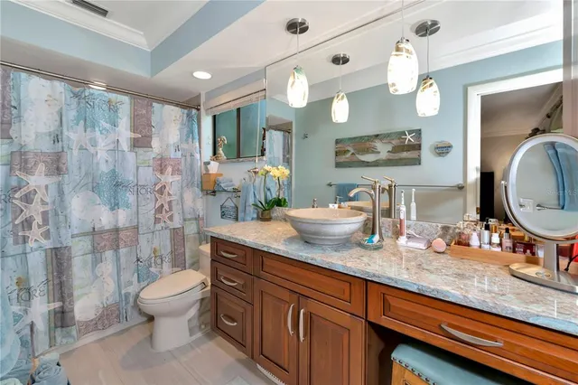 a spacious bathroom with a granite countertop sink a toilet a mirror and shower