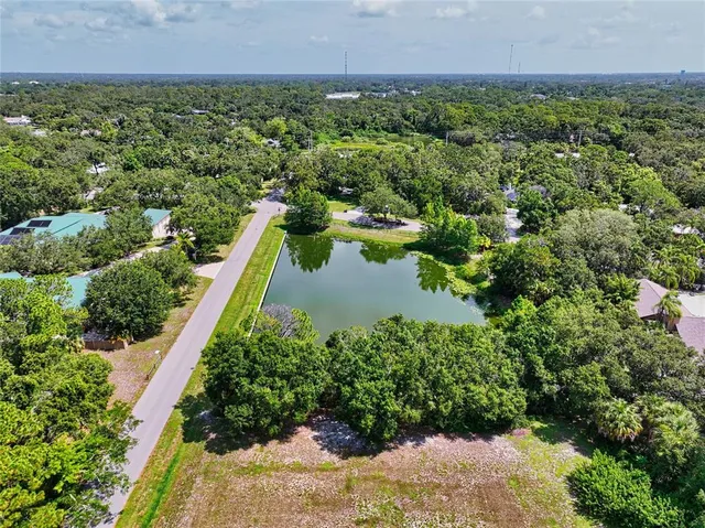an aerial view of residential house with outdoor space and trees all around