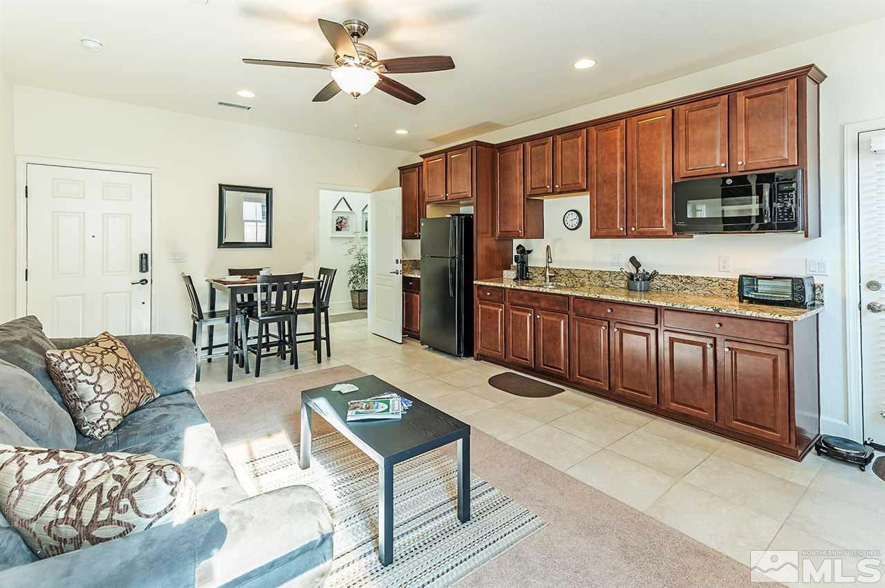 10350 Culiacan Pass Trail Reno, NV 89521 - Photo 16 of 20 a kitchen with stainless steel appliances granite countertop a refrigerator a sink dishwasher a dining table and chairs with wooden floor