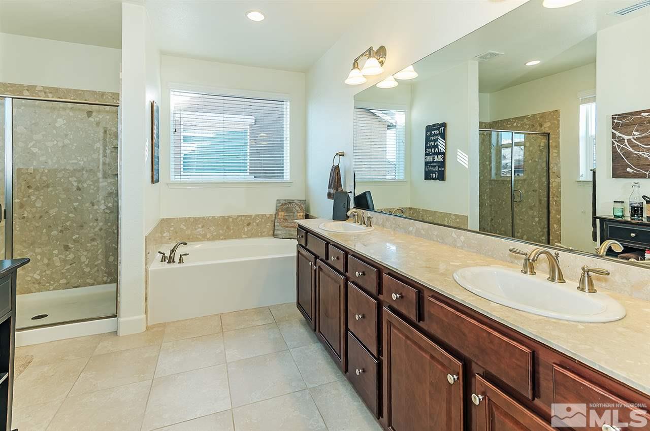 10350 Culiacan Pass Trail Reno, NV 89521 - Photo 10 of 20 a bathroom with a granite countertop bathtub sink vanity and mirror
