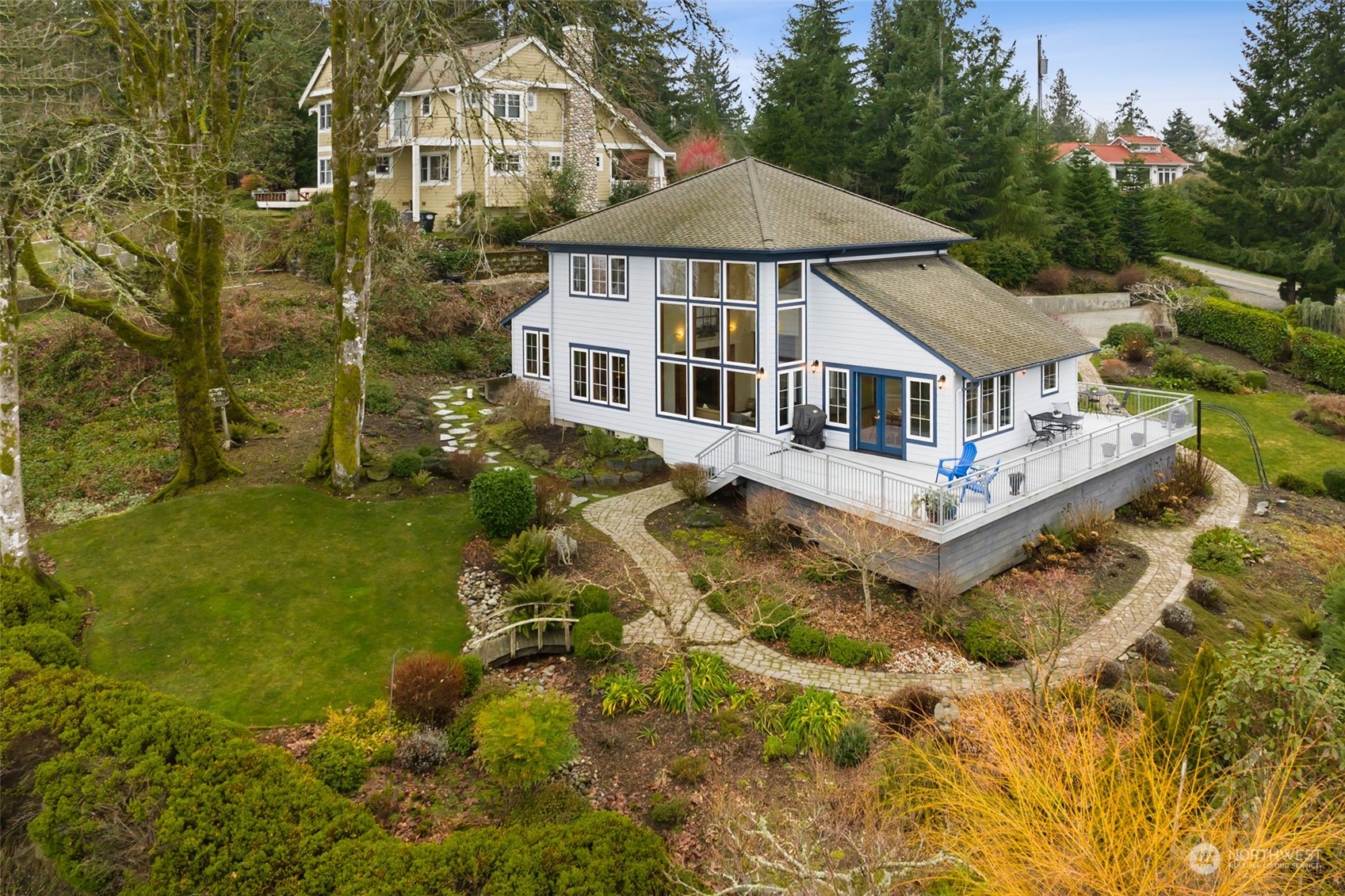 9942 Johnson Point Road Northeast Olympia, WA 98516 - Photo 33 of 34 a white house with a large pool and lawn chairs under an umbrella
