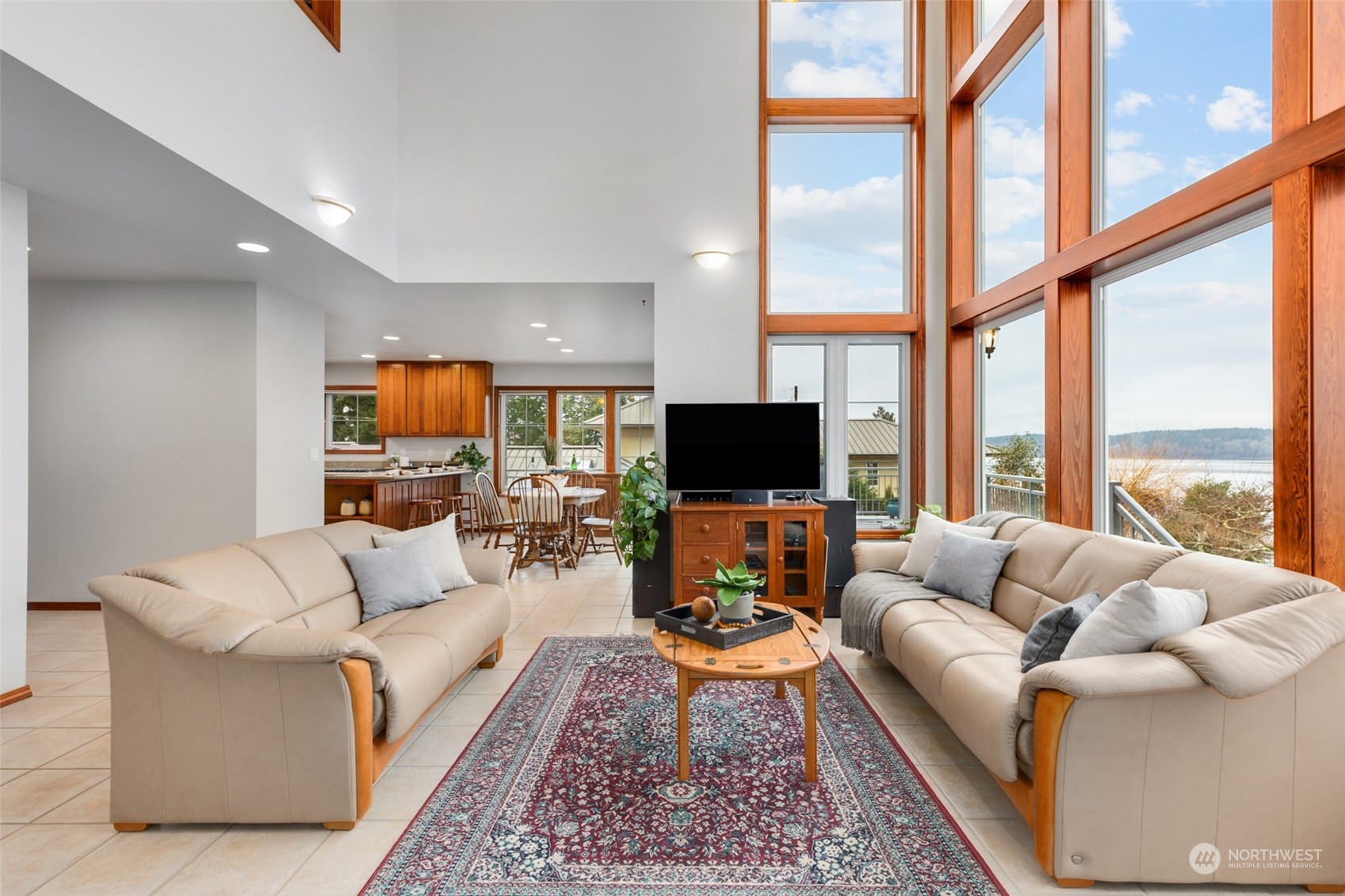 9942 Johnson Point Road Northeast Olympia, WA 98516 - Photo 6 of 34 a living room with furniture a large window and a flat screen tv