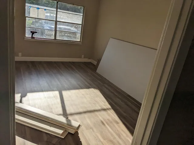 a view of a living room with wooden floor and windows