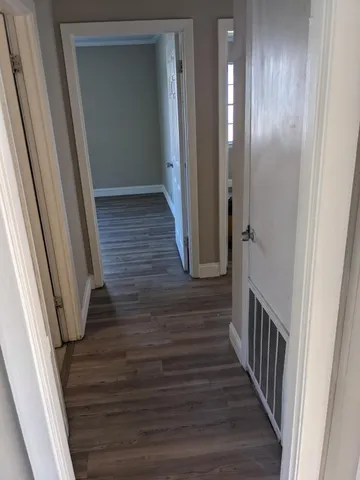 a view of a hallway with wooden floor
