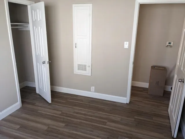 an empty room with wooden floor and closet