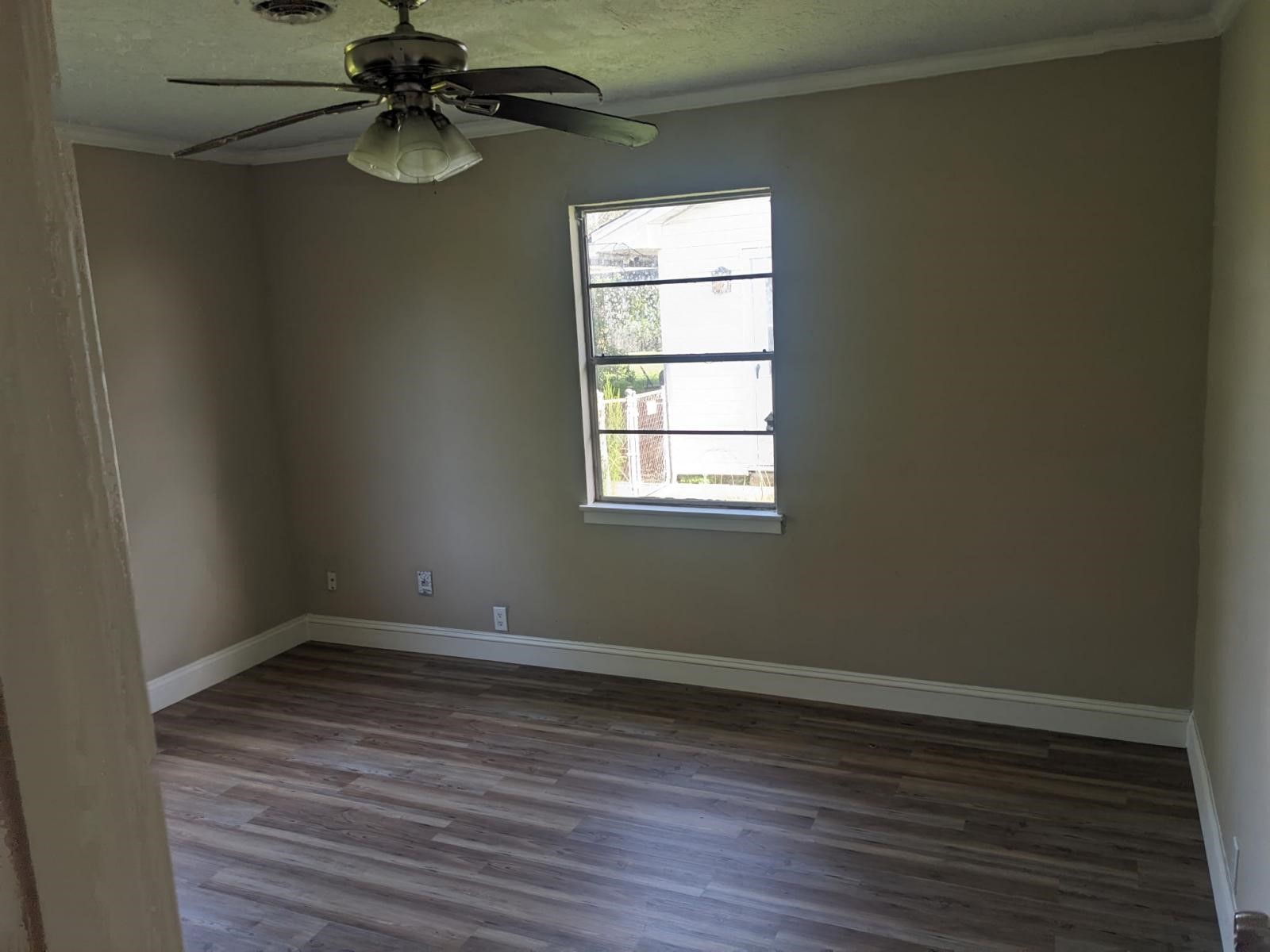 3470 Kipling Drive Beaumont, TX 77706 - Photo 2 of 21 an empty room with wooden floor fan and windows