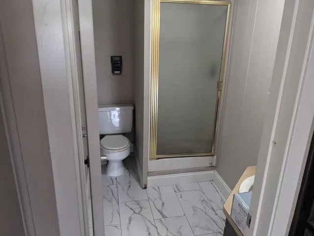 a bathroom with a toilet and a shower