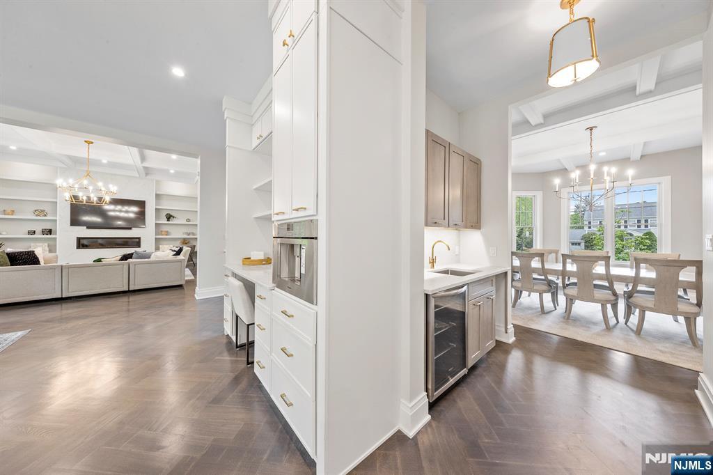 396 Knollwood Road Ridgewood, NJ 07450 - Photo 25 of 50 a kitchen with stainless steel appliances a stove top oven a sink a dining table and chairs with wooden floor