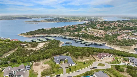 an aerial view of a city with lots of residential buildings ocean and mountain view in back