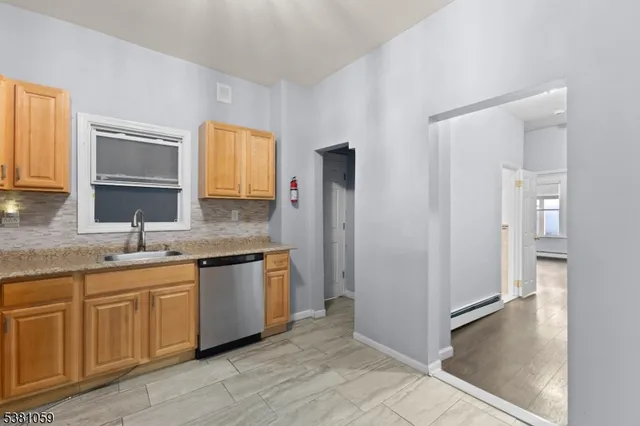 a kitchen with stainless steel appliances and wooden floor
