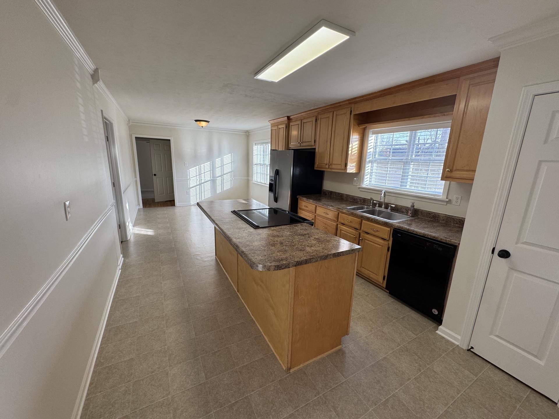 2823 Elmore Park Road Bartlett, TN 38134 - Photo 4 of 22 Kitchen featuring a kitchen island, crown molding, black appliances, and dark countertops