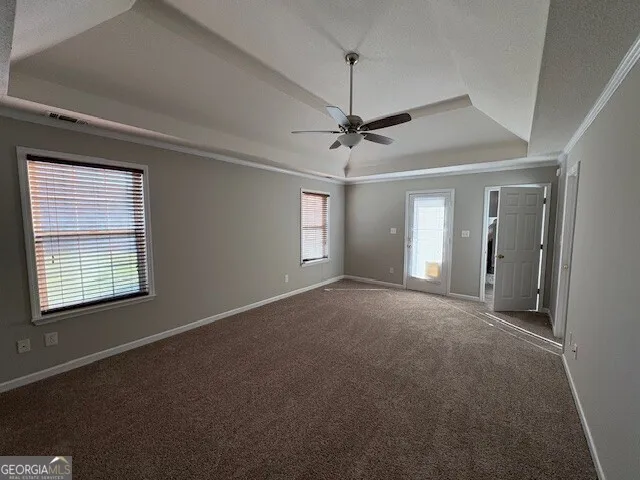a view of a room with a ceiling fan and window