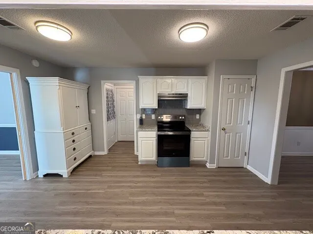 a kitchen with white cabinets and stainless steel appliances