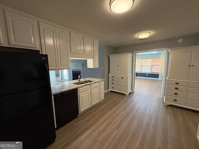 a kitchen with stainless steel appliances granite countertop a refrigerator a stove and a wooden floors