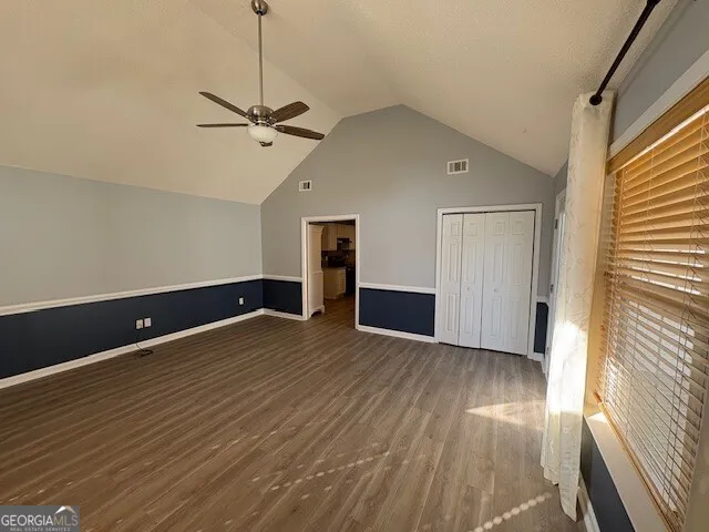 a view of empty room with wooden floor and fan