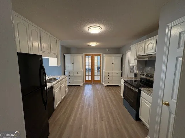 a kitchen with stainless steel appliances a refrigerator stove and wooden floor