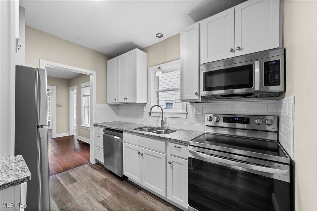 3165 Oak Road Cleveland, OH 44118 - Photo 13 of 30 Kitchen with stainless steel appliances, light stone counters, white cabinets, and dark wood-style floors