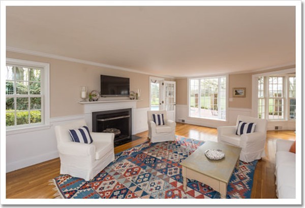 95 Gannett Road Scituate, MA 02066 - Photo 12 of 30 a living room with furniture a fireplace a flat screen tv and a large window
