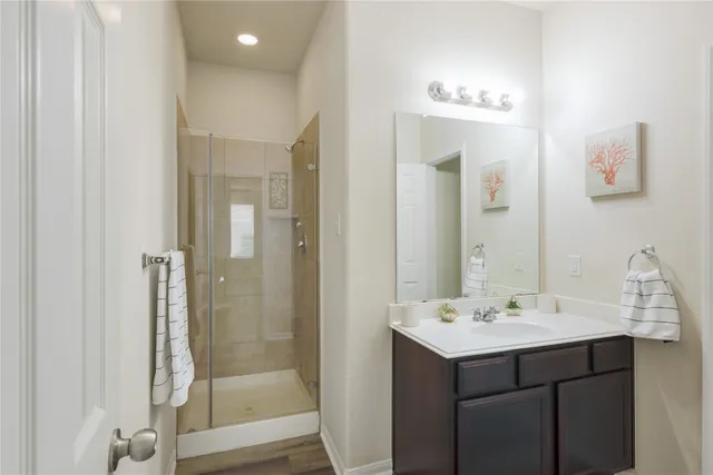 a bathroom with a shower sink and mirror