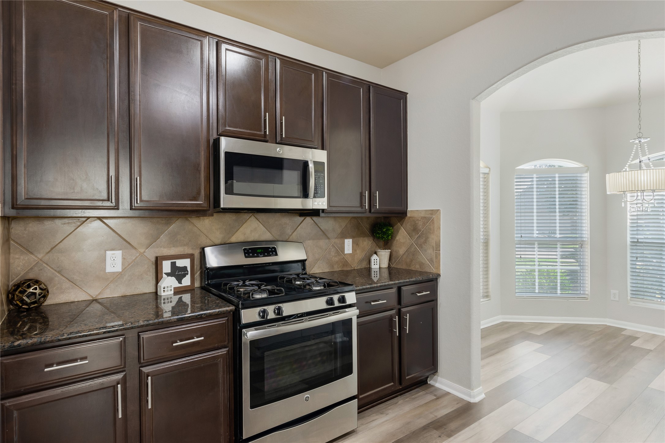 15007 Holland Grove Court Cypress, TX 77433 - Photo 5 of 28 a kitchen with granite countertop wooden cabinets stainless steel appliances and a window