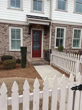 a view of a house with a small yard and wooden fence