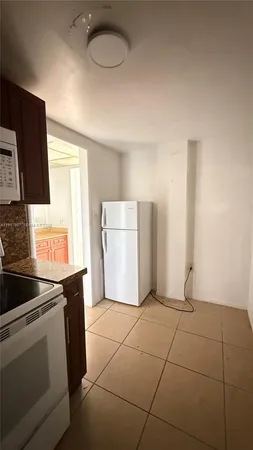 a kitchen with a sink a refrigerator and cabinets