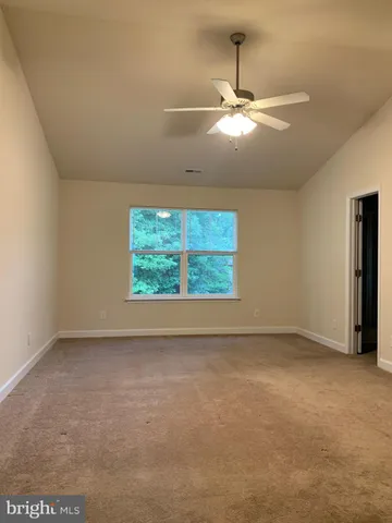 an empty room with a window and a fan